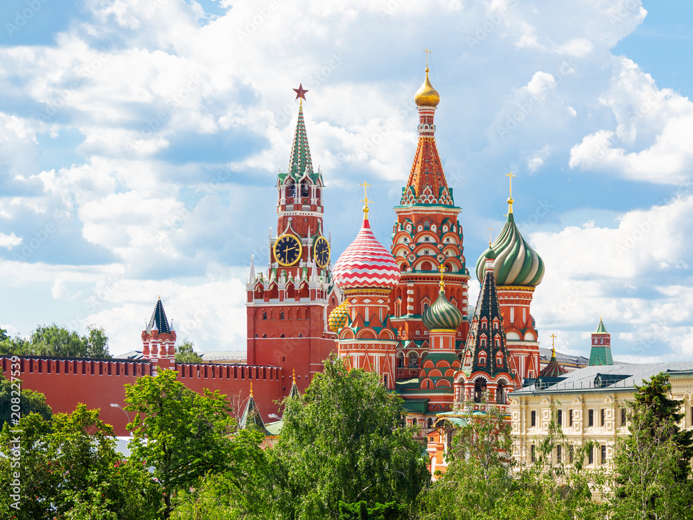 View on Saint Basil Cathedral and Spasskaya tower of Kremlin from Zaryadye park. Famous landmarks in sunny summer day. Moscow, Russia.