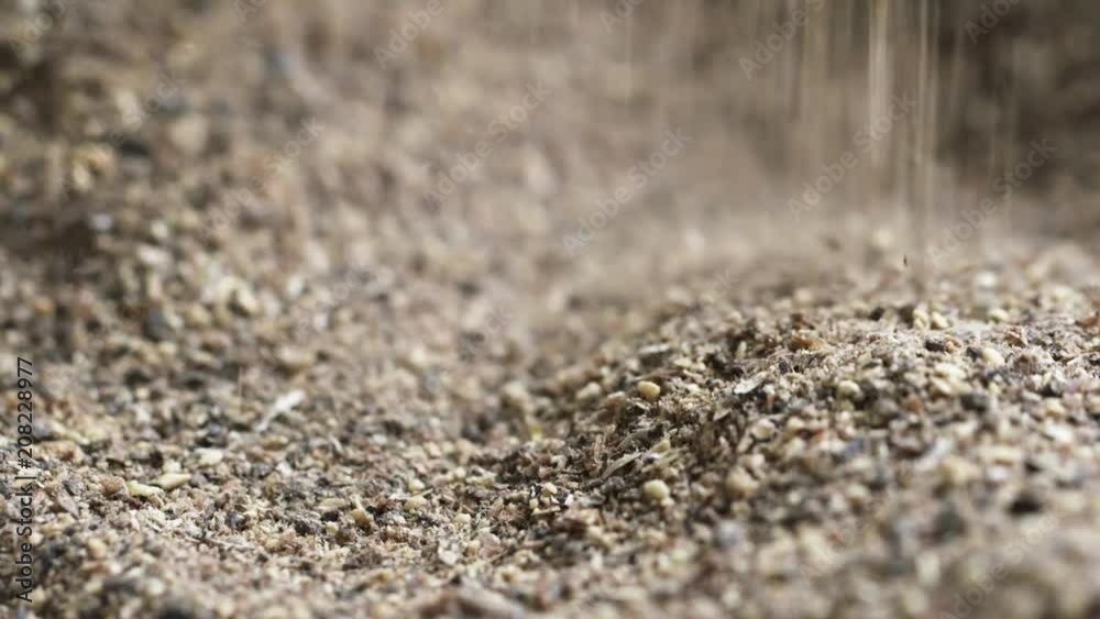 Crushed grain randomly falling down to linen bag with brown grind in slow motion. Macro close up Crushed grain randomly falling down to linen bag with brown grind in slow motion. Macro close up