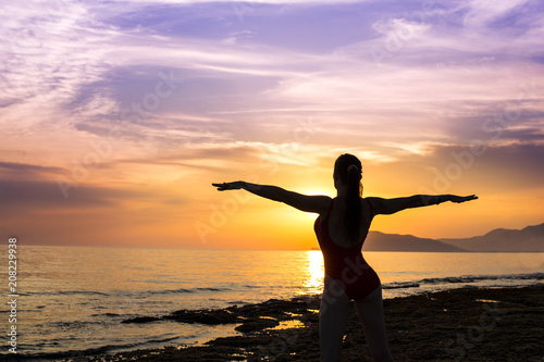 silhouette of woman on the sunset. yoga practice. © Stavros