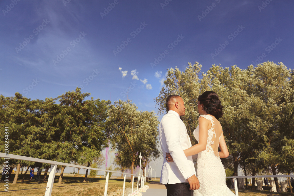 Beautiful wedding couple posing outdoor at dock