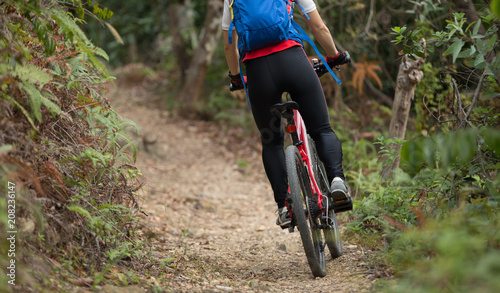 Fototapeta Naklejka Na Ścianę i Meble -  cyclist woman legs riding mountain bike on outdoor trail in forest