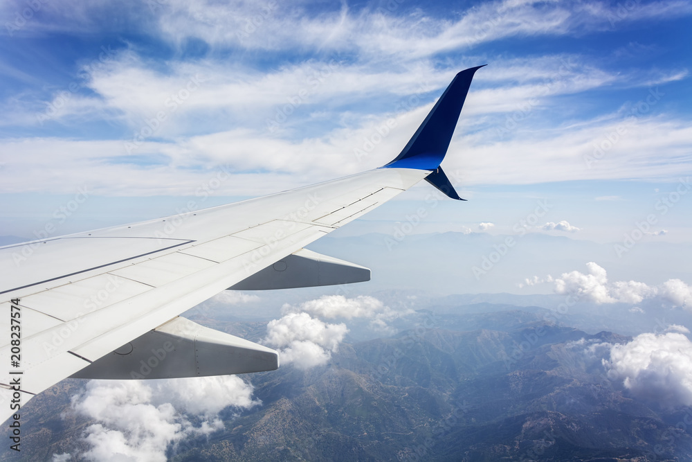 View from the airplane window. Clouds and landscape under the wing View from the airplane window. Clouds and landscape under the wing