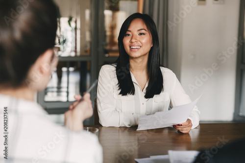 Obraz na plátně Business, career and placement concept - joyful asian woman smiling and holding