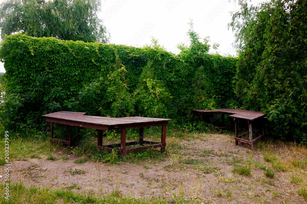 Wooden tables for rest on the grounds of the hotel or park.