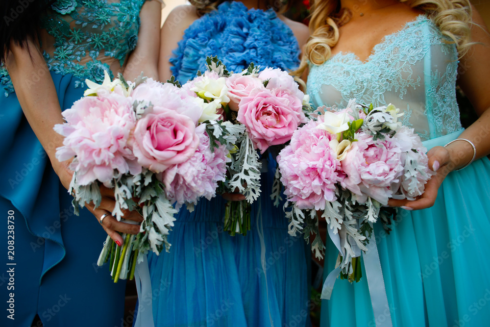 Bridesmaids in blue dress holding bouquet of flowers Bridesmaids in blue dress holding bouquet of flowers