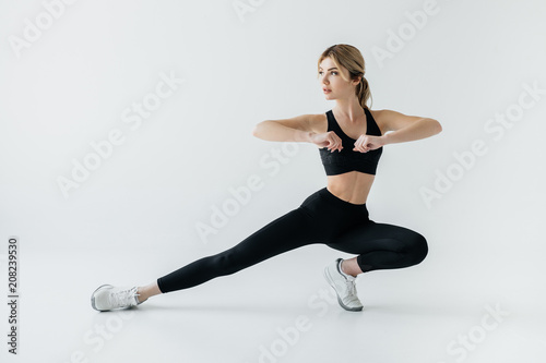 young athletic sportswoman exercising isolated on grey