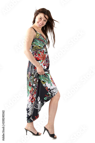 young beautiful woman in sundress with colorful flower pattern, playfully exposing the leg