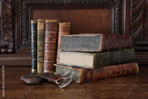 old books piled on an antique wooden furniture