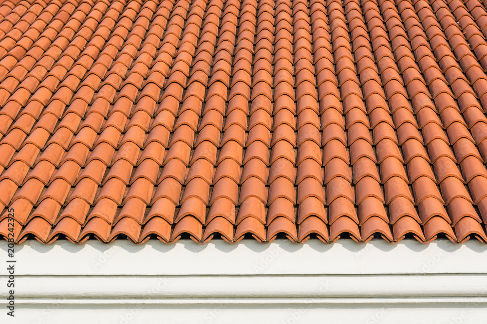 Red corrugated tile element of roof at house and white wall. Shingles roofing surface tiles overlay pattern and texture