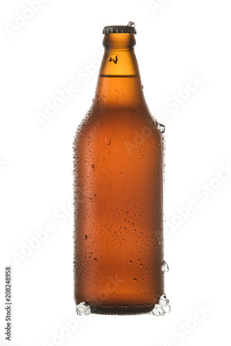 Cold beer with pieces of ice and drops by the bottle on white background