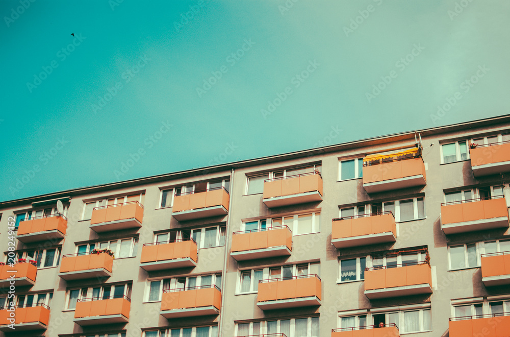 Old socialist residential building and summer blue sky. Vintage retro colors