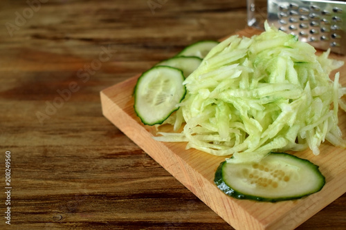 Grated cucumber on a wooden board. Ingredient for a meal