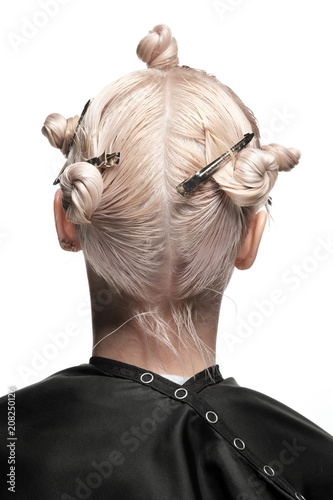 Hair coloring in blond. Preparation for hair cutting. Work stylist of the hairdresser in the salon on a white background.
