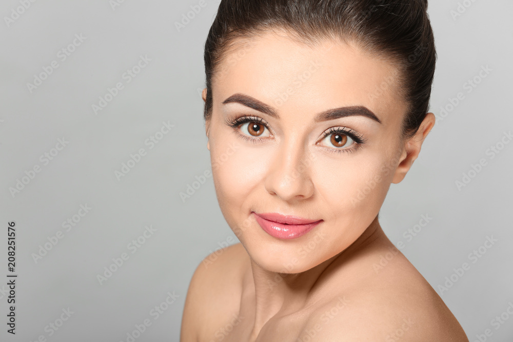 Beautiful young woman with silky skin after spa treatment on light background Beautiful young woman with silky skin after spa treatment on light background