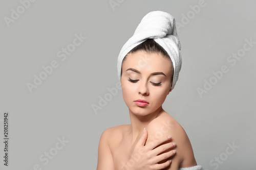 Beautiful young woman with silky skin after spa treatment on light background