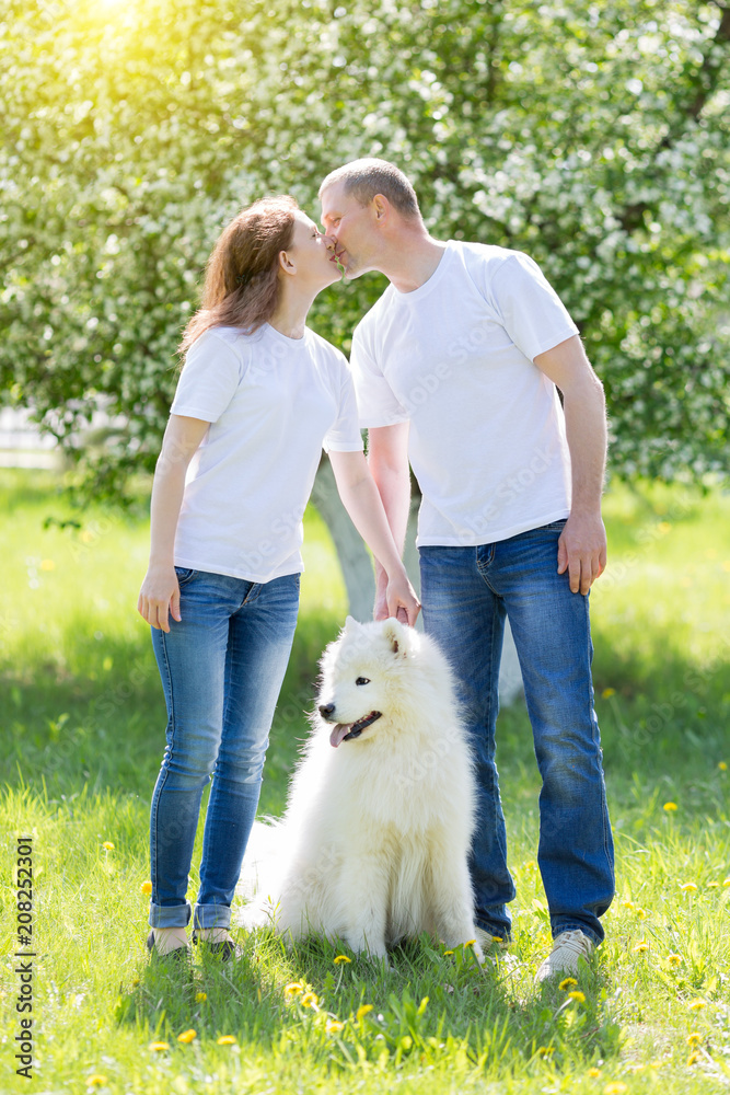 Enamored people are walking with a dog in the countryside. A man with a woman and her dog is meeting in the park. Enamored people are walking with a dog in the countryside. A man with a woman and her dog is meeting in the park.
