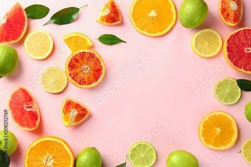 Composition with cut citrus fruits on color background, top view
