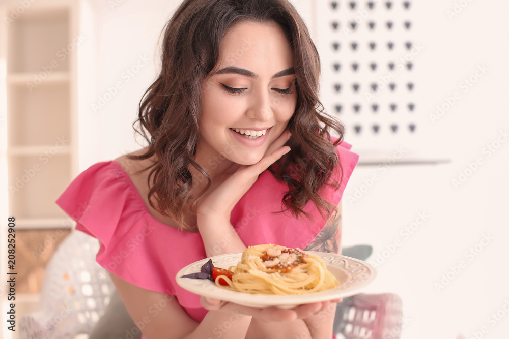 Young woman with plate of tasty pasta at home Young woman with plate of tasty pasta at home