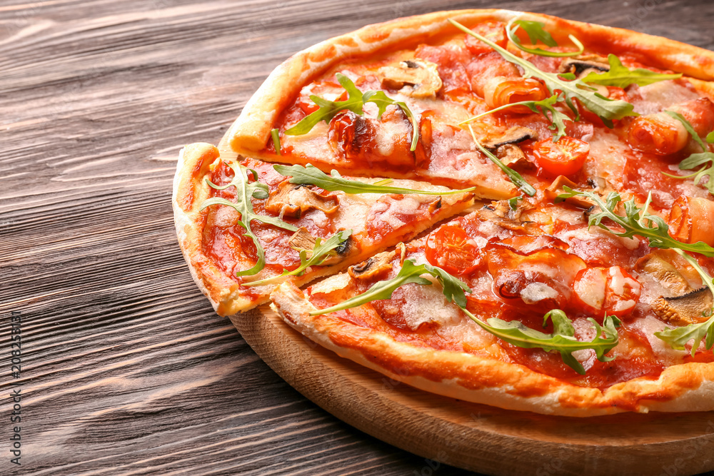 Tasty pizza with fresh arugula on wooden table