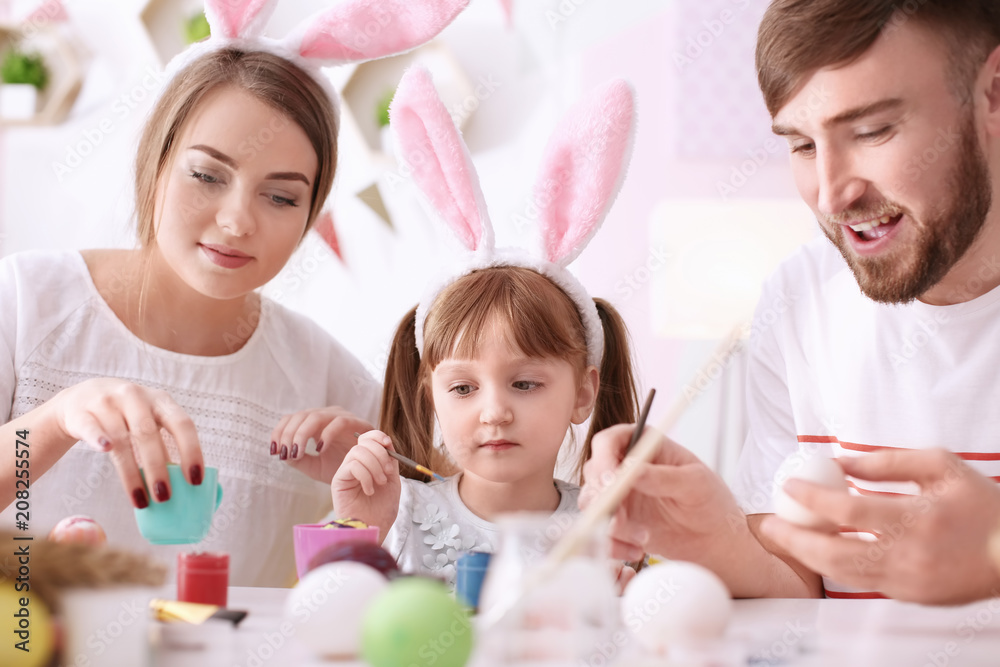 Family painting Easter eggs together at table Family painting Easter eggs together at table