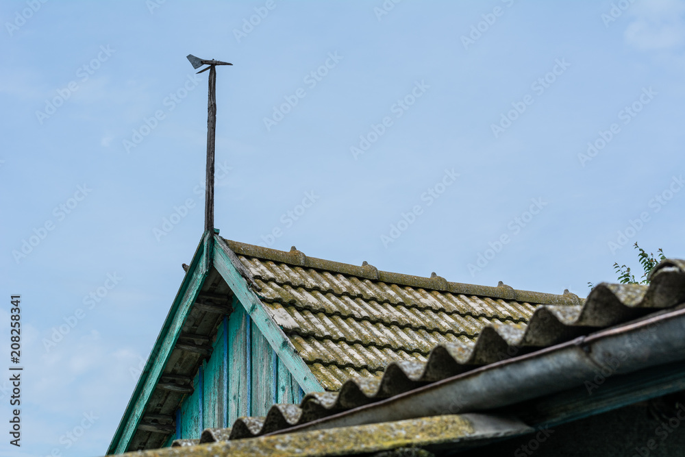 Fototapeta premium Weathervane on the roof of the old house