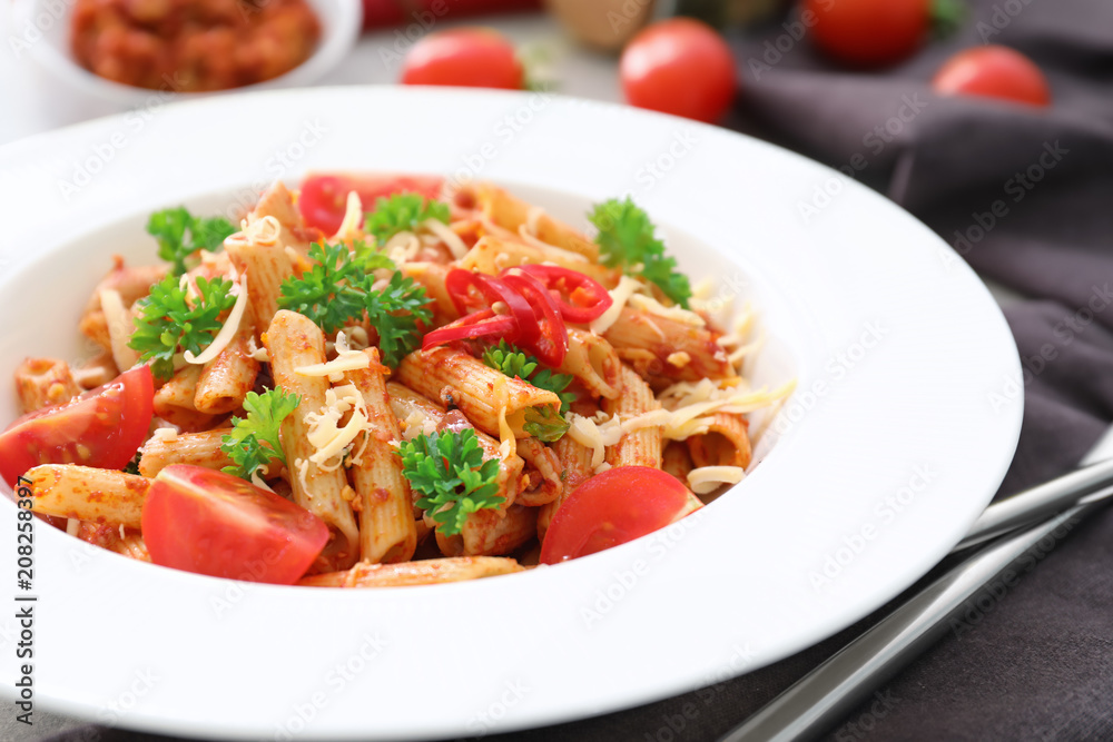 Plate of tasty penne pasta with tomato sauce on table, closeup Plate of tasty penne pasta with tomato sauce on table, closeup