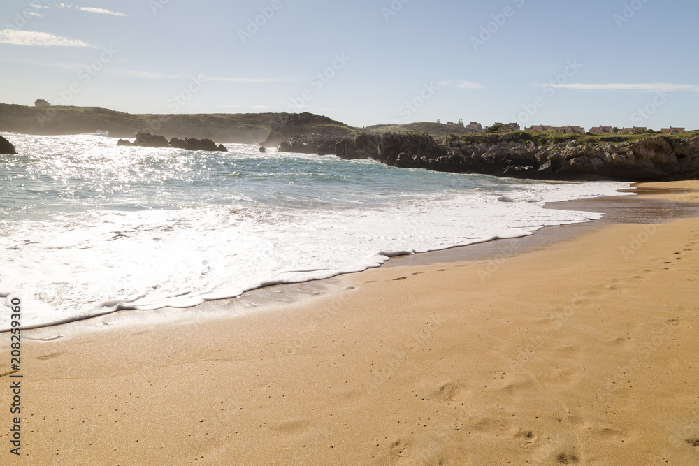 beautiful beach with waves breaking on the shore and without people
