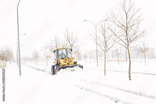 Snowplow cleaning a street in a city full of snow in winter 