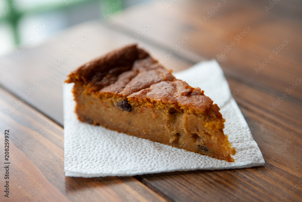 pumpkin cake with walnuts, prunes and dried raisins on a dark wood background cafe. selective focus