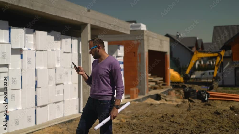 Male architect with smartphone checking project at new house
Male architect with smartphone checking project at new house