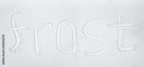 Hand written word frost drawing on fresh snow