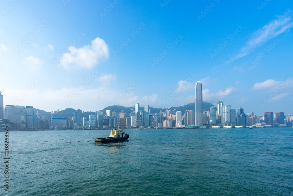 Naklejka premium Hong Kong skyline cityscape, boat at Victoria Harbor in morning