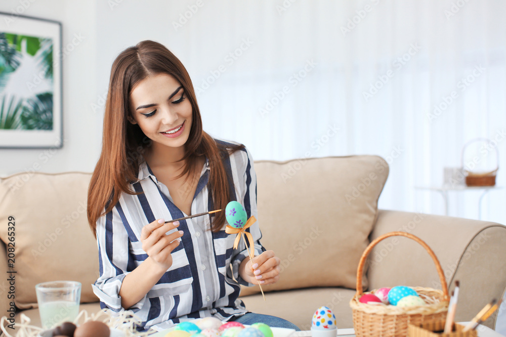 Beautiful young woman painting Easter eggs at home Beautiful young woman painting Easter eggs at home