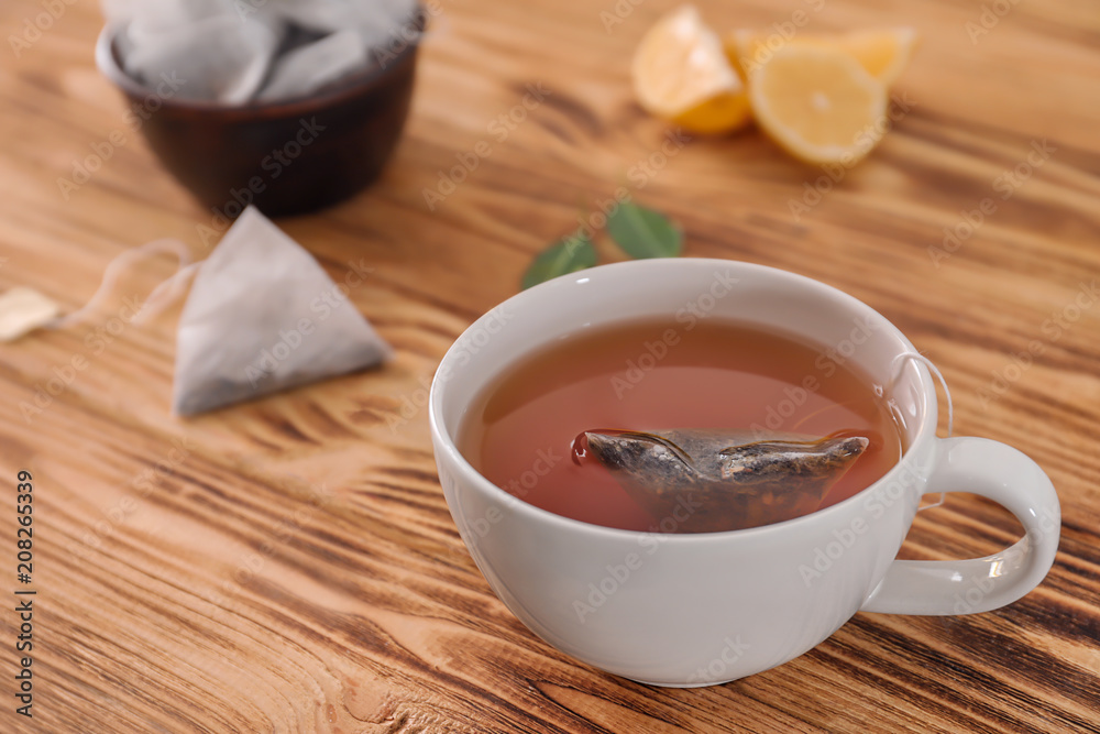 Cup with delicious tea on wooden background