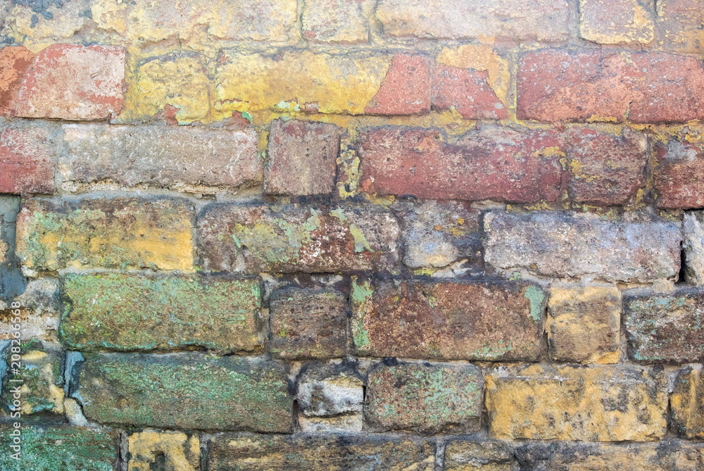 Fototapeta premium Photo of an old dilapidated multi-colored stone wall