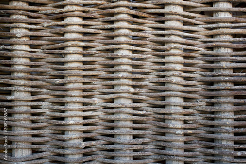 Woven from rods wooden fence. The texture of the wood and netting.