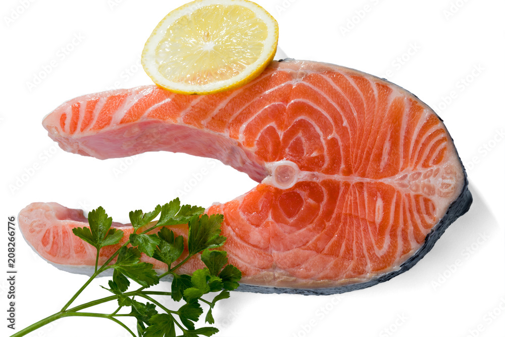 Salmon steak with a sprig of parsley and lemon slice isolated on a white background.. Salmon steak with a sprig of parsley and lemon slice isolated on a white background..