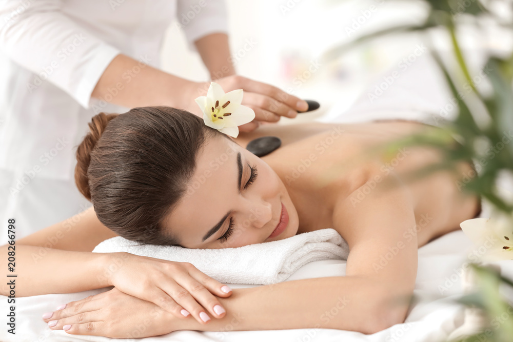 Young woman enjoying stone massage in spa salon Young woman enjoying stone massage in spa salon