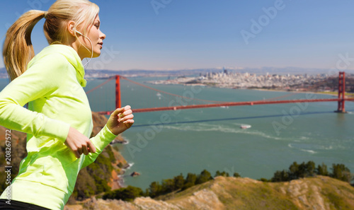 Photography fitness, sport and technology concept - happy woman running and listening to mus
