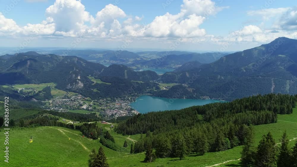 Aerial panoramic view of lake Wolfgangsee in summer, scenery with majestic lush green slopes and peaks of Alps mountains, alpine town St Gilgen - picturesque landscape of Austria from above, Europe