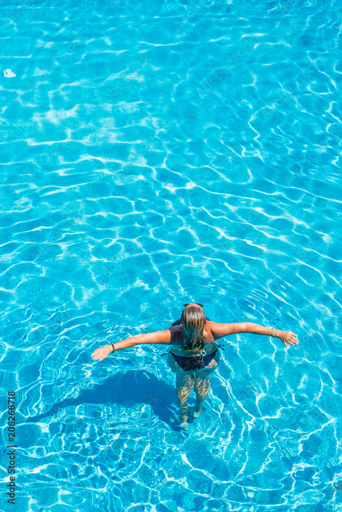 woman relaxing in infinity pool at luxury resort spa retreat.