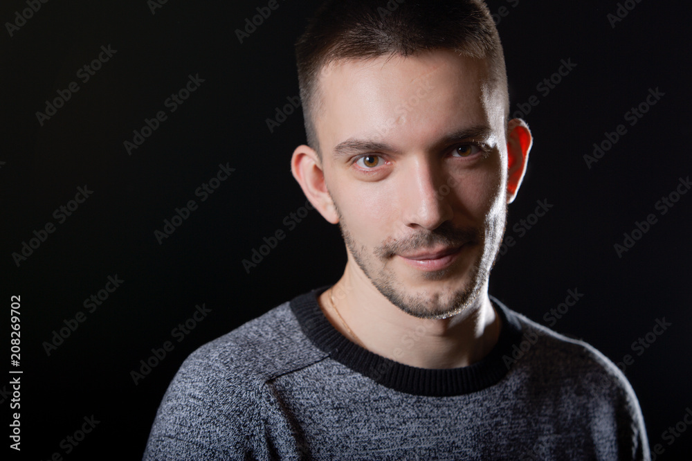 Fototapeta premium Portrait of a handsome young man. Black background.