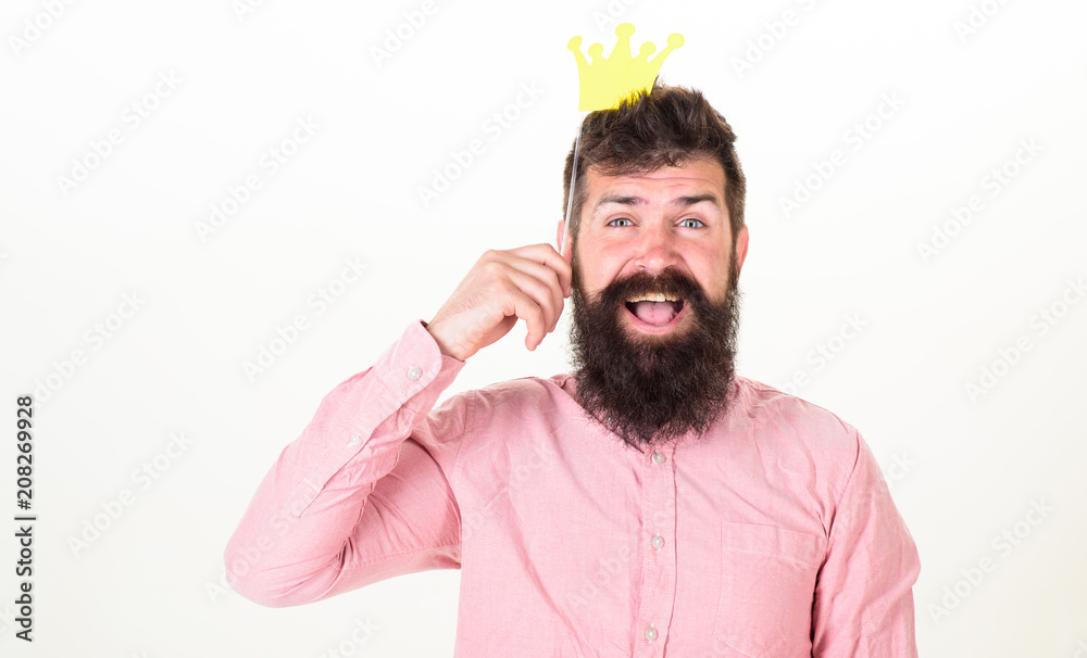 Party king, birthday concept. Happy bearded man on white background. Man with long beard and open mouth holding paper crown. Hipster with excited look and trendy beard posing with paper accessories Party king, birthday concept. Happy bearded man on white background. Man with long beard and open mouth holding paper crown. Hipster with excited look and trendy beard posing with paper accessories