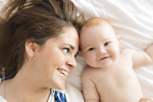 Bilde på lerret happy mother with baby in bed at home