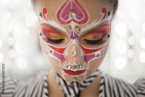Young beautiful woman with skull makeup close her eyes