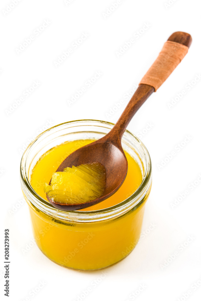 Ghee or clarified butter in jar and wooden spoon isolated on white background Ghee or clarified butter in jar and wooden spoon isolated on white background