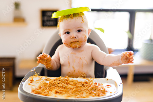 Photos Little baby girl eating her spaghetti dinner and making a mess