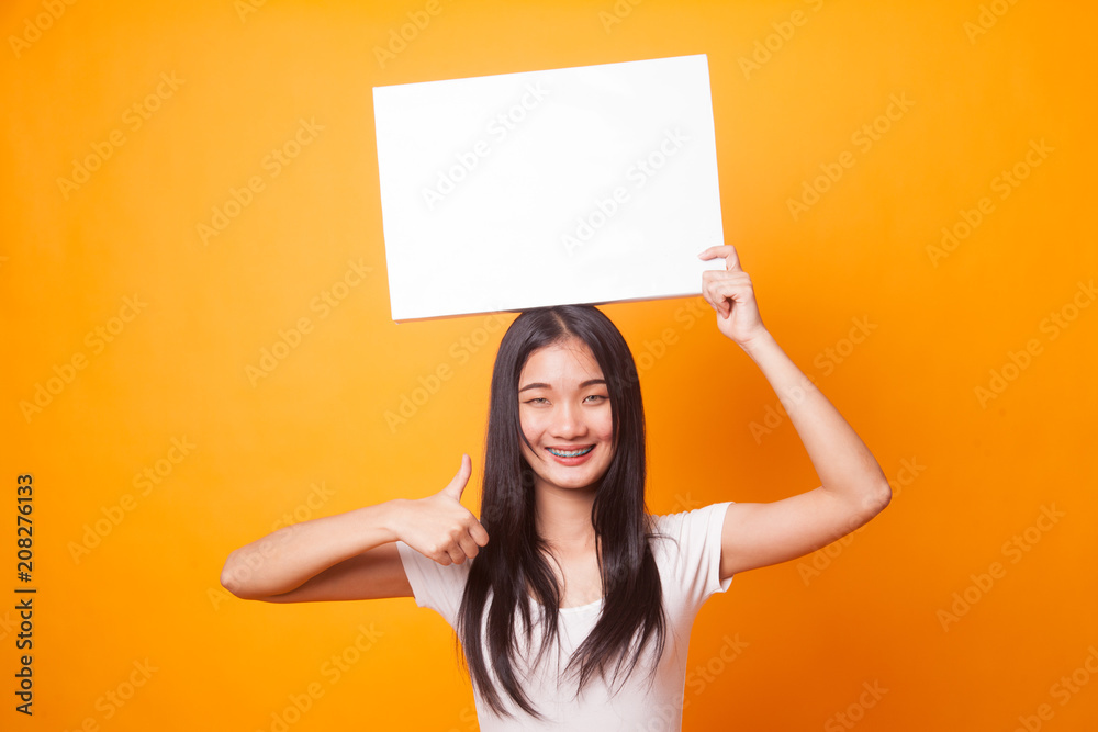 Young Asian woman show thumbs up with white blank sign. Young Asian woman show thumbs up with white blank sign.
