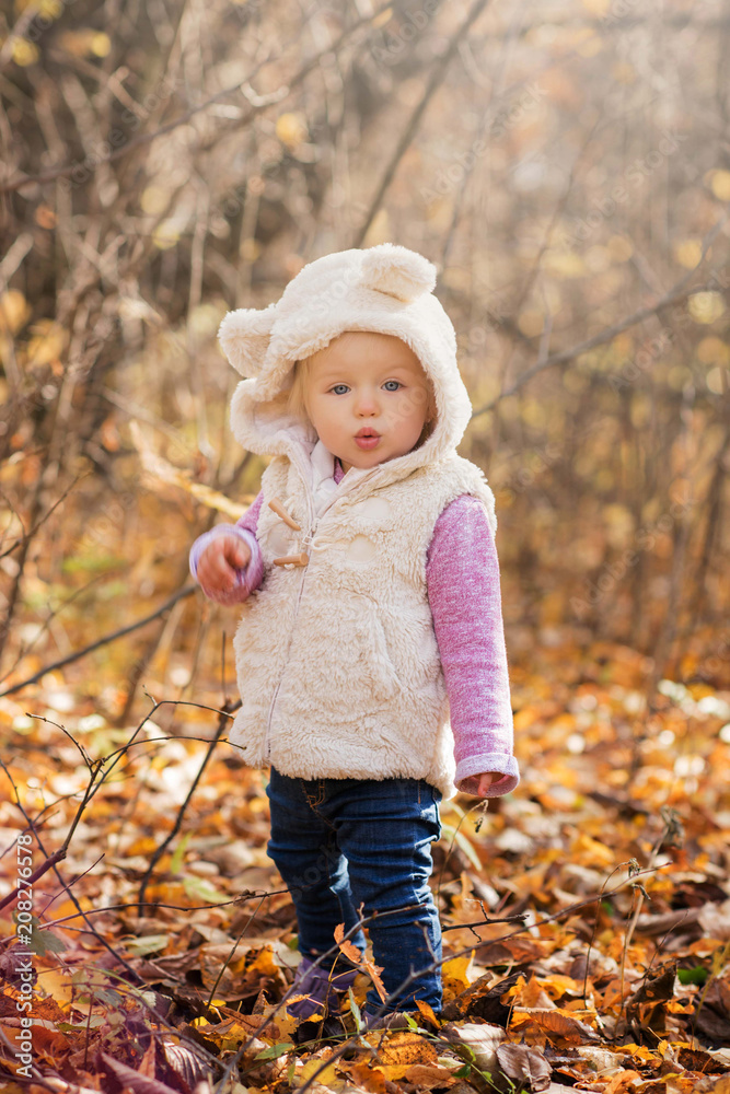 cute little girl doing a pout blowing kiss in a autumn park cute little girl doing a pout blowing kiss in a autumn park