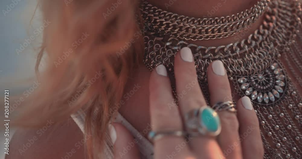 Close-up of boho woman wearing silver rings and necklace outdoors